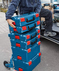 Person transporting stackable tool storage case with 1-click lock, top front and side handles for easy transport, built tough for trade pros and DIY, 4.5 in by 14 in by 17.5 in, blue