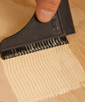 Comb squeegee from Complete Silicone Glue Kit For Woodworking And Crafts spreading glue on wood surface