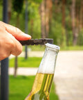 Tactical EDC Pry Bar For Survival And Everyday Carry Three Point Eight Inch Multitool opening a bottle outdoors