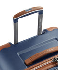 Close-up view of Delsey 26-inch spinner luggage with navy blue basketweave textured polycarbonate shell and faux leather accents