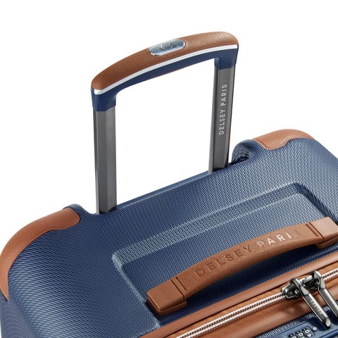Close-up view of Delsey 26-inch spinner luggage with navy blue basketweave textured polycarbonate shell and faux leather accents