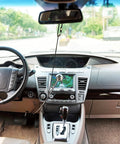Wingbrake-V driver training brake hanging from rearview mirror inside a sedan; black cord with silver knob.