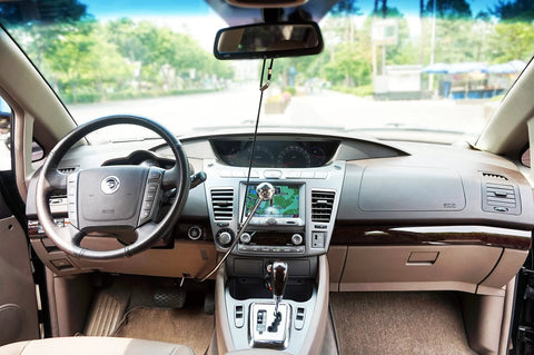 Wingbrake-V driver training brake hanging from rearview mirror inside a sedan; black cord with silver knob.