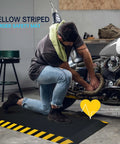 Man working on motorcycle with Anti Fatigue Standing Mat For Workstation Ultra Cushy High Density Memory Foam Ergonomic Floor Pad To Fight Leg And Back Pain Industrial Grade Durability 24 By 70 Inches With Yellow Border