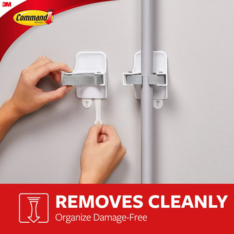 Smooth Broom And Mop Gripper Organizer With Adhesive Strips For Damage Free Hanging Holds Up To Four Pounds For Handles Ranging From Point Eight To One Inch Handy Home Cleanup Solution being used on a wall to hold a handle securely.