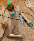 Killer Stainless Steel Folding Pocket Knife With Integrated Wine Corkscrew And Bottle Opener Solid Beechwood Handle on wood.