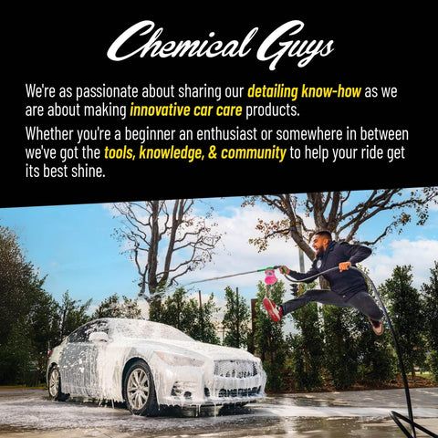 Person washing a car with foam using a hose outdoors under trees.