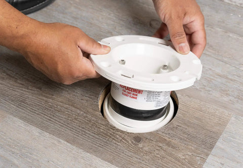 Hands installing Four Inch Closet Flange Replacement for Toilets with Adjustable Compression Joint into floor pipe