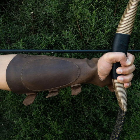 Archery Bracer With Thumb Slot And Adjustable Buckle Straps, Full Grain Leather Forearm Protector in use with bow