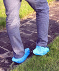 Slip Resistant Disposable Boot And Shoe Covers Blue Large 50 Pairs Pack Pro Grade Heavy Duty Non Woven 35G Easy Slip On Fits Up To Men Size 11 And Women Size 13 being worn outdoors on a brick path
