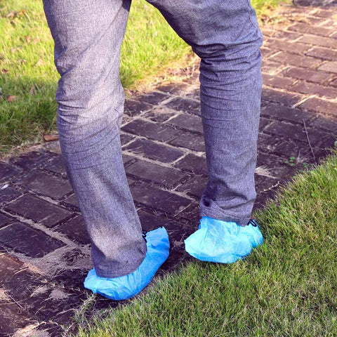 Slip Resistant Disposable Boot And Shoe Covers Blue Large 50 Pairs Pack Pro Grade Heavy Duty Non Woven 35G Easy Slip On Fits Up To Men Size 11 And Women Size 13 being worn outdoors on a brick path