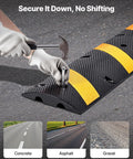 Person securing Beefy Rubber Driveway Speed Bumps 2-Pack, 6-Foot 2-Channel Modular Traffic Humps with screws on asphalt surface.