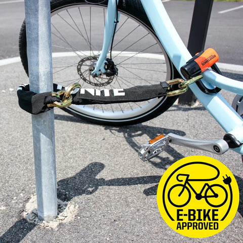 Beefed Up Heavy Duty 12mm Hardened Manganese Steel Bike Chain Lock securing blue bike to pole, E-Bike approved logo visible