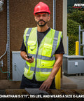 Built Different Neon Yellow Safety Vest With ANSI Class Two Reflective Striping And Nine Roomy Pockets For Construction Teams And Roadside Pros Wanting Top Shelf Coverage Locked In On Every Job Site, worn by worker, size XL.