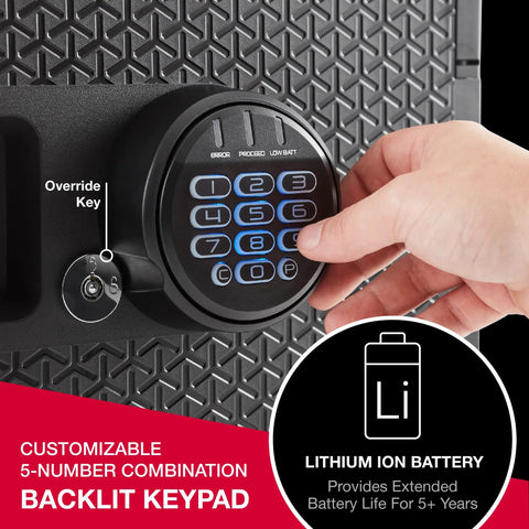 Hand operating backlit digital keypad on Beefy Fireproof And Waterproof Safe with override key, focus on security features.