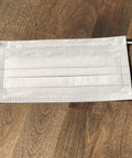Made In USA 3 Layer Disposable Face Masks Bulk Pack 500 Count 6.69 Inches Long By 3.74 Inches Wide With Ear Loop Medical Procedure Masks And Meltblown Filter Layer on wooden surface