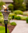 Easy Pour Mosaic Torch For Outdoor Vibes, gray ceramic tile torch with weather resistant steel, lit in garden setting