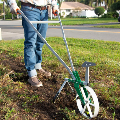 Person using High Wheel Garden Cultivator With Self Cleaning Steel Wheel Hoe And Modular Plow For Gardening in a garden