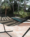 XXL Handwoven Mayan Double Hammock For Outdoor Use With Thick Cord 156 Inch Wide 90 Inch Deep And 625 Pound Capacity in Black and Natural installed by a poolside