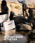 Latitude Marine Ultra White 25 Quart Cooler With Cool Riser Technology ThermoCool Foam Insulation used by anglers by a stream.