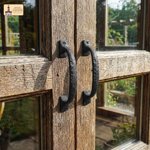 Twisted Grip Mystic Colonial Rustic 6.5 Inch Barn Door Handle Pull for Sliding Barn Doors in black wrought iron on a wooden gate.