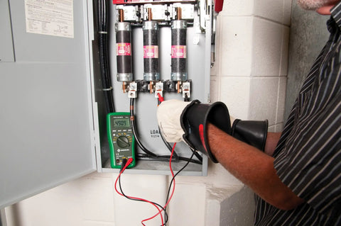 Electrician using Digital Multimeter DM 65 1000V AC And DC 10A Capacitance Temperature Meter in power panel testing voltage