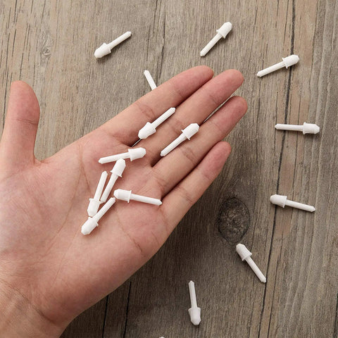 Top Shelf White Shutter Repair Pins Twenty Pack One By Point Two Five Inch Louver Pins in hand on wooden surface.