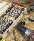 Heavy Duty 16 Piece Forstner Drill Bit Set With Precision Shear Serrated Edges in wooden case with various bits on workbench.