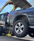 Truck with Two Pack Truck Bed Anchor Kit securing cargo using ratchet straps, visible anchor on tailgate, rugged polyester webbing.