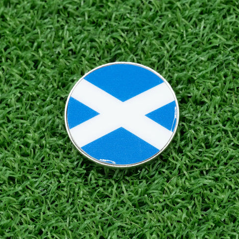 St Andrews Cross Golf Ball Marker Dope Premium Metal Alignment Tool 1 Inch Marker on green grass, blue with white cross.