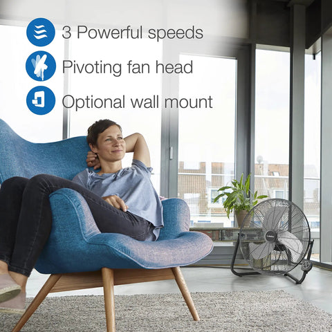 Woman relaxing in chair with 20 Inch High Velocity Wall Mount Fan With Pivoting Head, Remote, 3 Speed Settings shown nearby