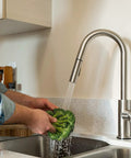 Man washing lettuce under RV Ready Pull Down Kitchen Faucet With One Hand Lever, Detachable Spray Head, And Optional Deck Plate In Brushed Satin Nickel