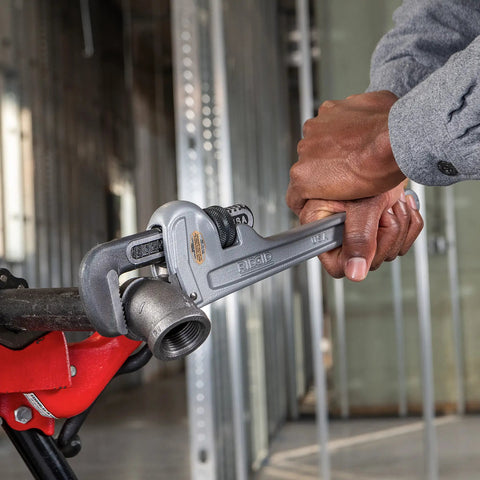Using a 14 Inch Aluminum Straight Pipe Wrench For 2 Inch Pipe Capacity with Quick Ratcheting Action on a metal pipe