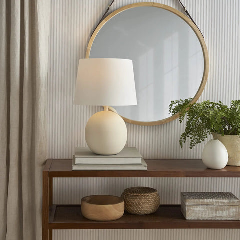 18 Inch Off White Round Metal Table Lamp With Black Cord on wooden console in modern living room setting