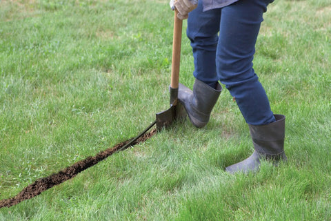 Person digging trench for DIY Self Install In Ground Automatic Sprinkler System Kit For Medium Lawn No Sweat Auto Watering From Outdoor Faucet With Retractable Sprinklers For A Clean Lawn Look.