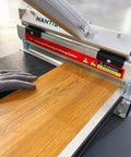 Pro Grade Floor Cutter For Laminate And Vinyl With Quick Install Kit cutting laminate plank at 45 degrees, with gloved hand