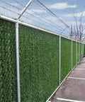 Heavy Duty Privacy Hedge Slats For Chain Link Fence No Fuss Outdoor Privacy Screen For Balcony Patio Yard And Garden Delivers Up To 90 Percent Blockage With Lush Hedge Look Ideal For Pets And Cozy Enclosed Spaces installed along a fence in a parking lot