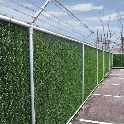 Heavy Duty Privacy Hedge Slats For Chain Link Fence No Fuss Outdoor Privacy Screen For Balcony Patio Yard And Garden Delivers Up To 90 Percent Blockage With Lush Hedge Look Ideal For Pets And Cozy Enclosed Spaces installed along a fence in a parking lot