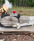 High Pressure Cast Iron Round Burner Head With Brass Fitting Regulator And Four Foot Hose Included Universal Replacement For Outdoor Grills Griddles And Propane Stoves Supports 0 To 20 Psi displayed outside near a campfire