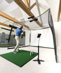 Person practicing with Indoor Golf Practice Net With 10x8 Ft Hitting Net And Impact Screen, Knotless Design in a home setup.