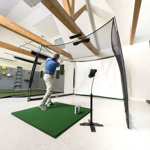 Person practicing with Indoor Golf Practice Net With 10x8 Ft Hitting Net And Impact Screen, Knotless Design in a home setup.