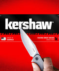 Hand holding Filter Frame Lock Knife In Stainless Steel With A 3.25 Inch BlackWash Drop Point Blade For Everyday Carry against red