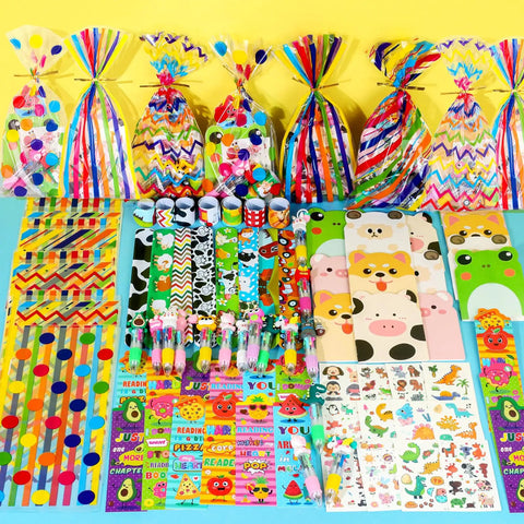 All In One Stationery Party Pack For Kids With 24 Goodie Bags Mini Notebooks Multicolor Pens Slap Bracelets Motivational Bookmarks Tattoos Classroom Gifts Class Rewards And Prizes displayed on table