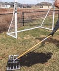 Person using 30-Inch Lawn Leveling Rake With 72-Inch Handle, Stainless Steel Tray, in garden behind soccer goal, effortless garden leveling