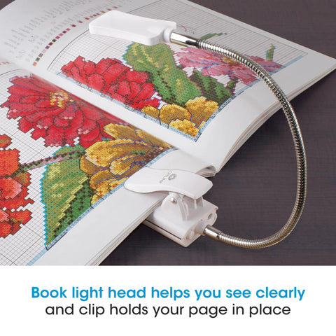 2 In 1 Sewing Machine Light With Clip On Lamp And Magnifier attached to a book with colorful embroidery design