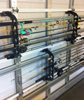 Garage Door Storage Rack for Fishing Gear 21 Inch Black ABS Rod Holder on garage door holding multiple fishing rods.