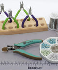 Metal Hole Punch Pliers With Gauge Guard for 22 gauge metal, displayed with bead tools and materials for jewelry making