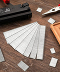 Premium 18 Gauge Brad Nails In 2 Inch One Quarter And Three Quarters Lengths Rock Solid Zinc Plated Steel arranged beside a nail gun.