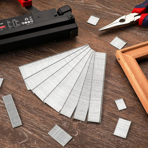 Premium 18 Gauge Brad Nails In 2 Inch One Quarter And Three Quarters Lengths Rock Solid Zinc Plated Steel arranged beside a nail gun.