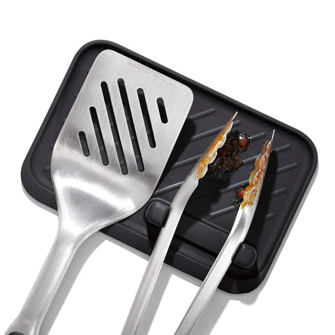 Outdoor Grilling Turner And Tongs Set With Heavy Duty Stainless Steel Construction on black tray, showing wide beveled head.